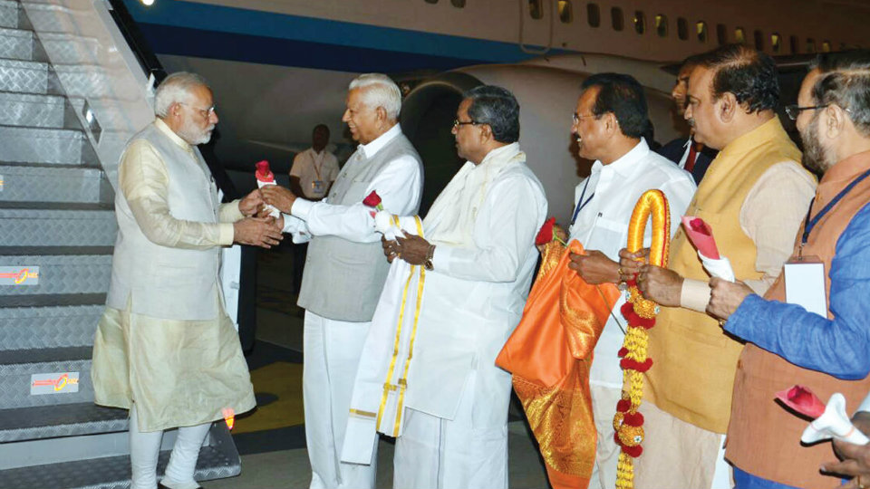 Say it with Roses: Governor, CM receive PM Modi at night in Mysore Airport