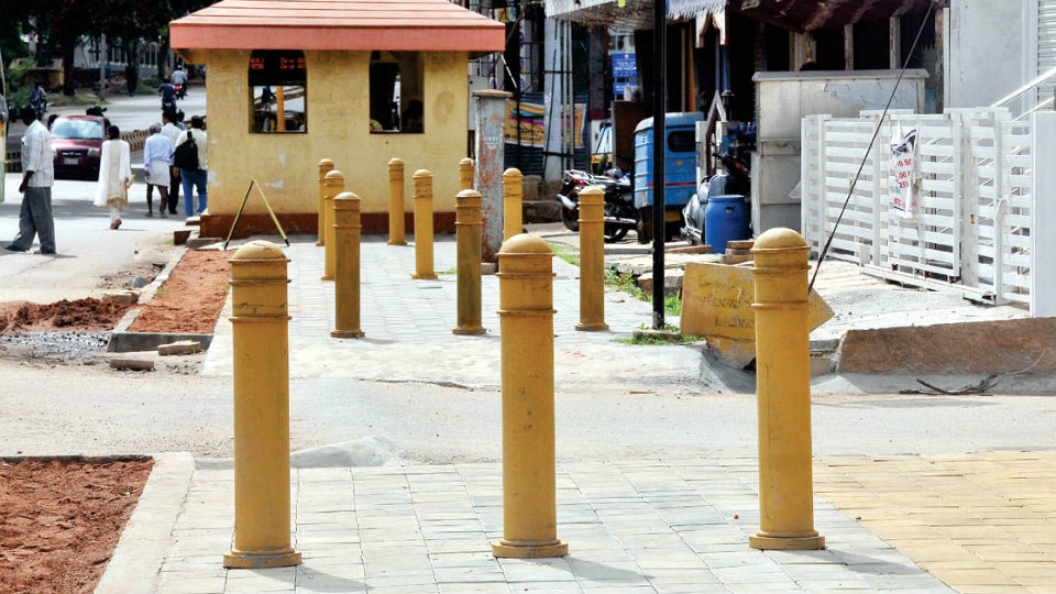 Install iron bollards to prevent footpath encroachment