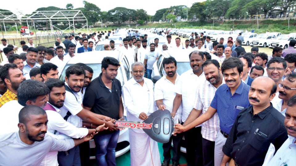 District Minister distributes taxis to beneficiaries
