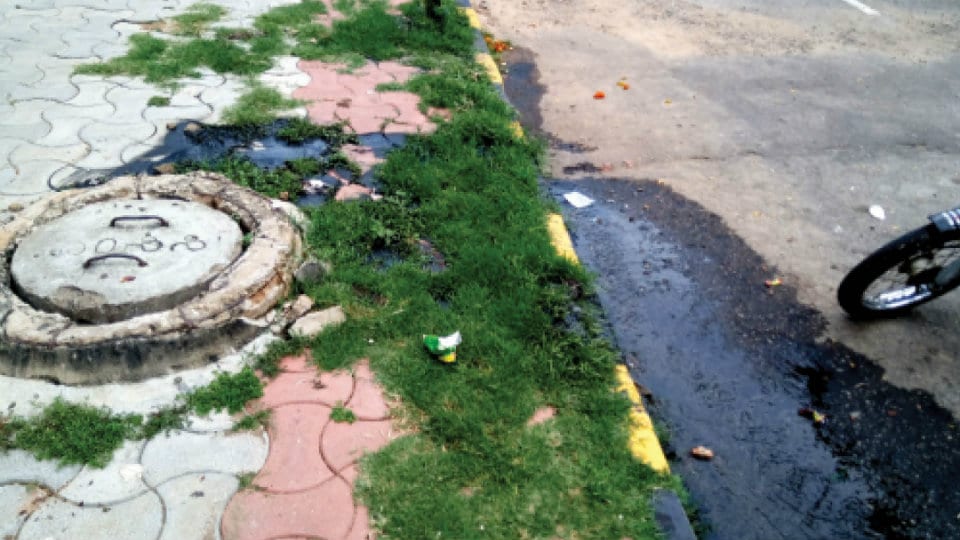 Plug overflowing manhole on Hunsur Road in Vijayanagar