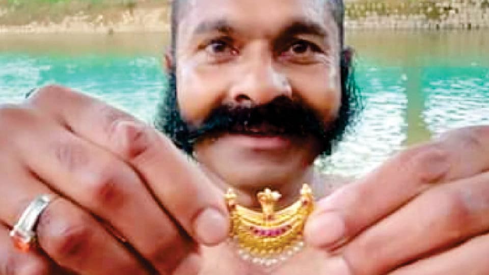 Diver fishes out gold ornament from Cauvery River