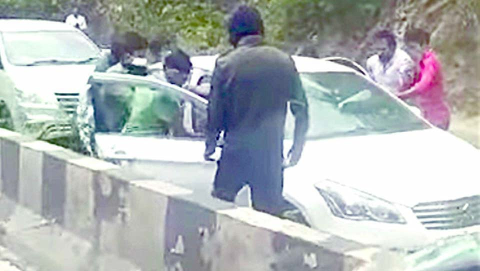 Gang waylays car in full public view; flees with it