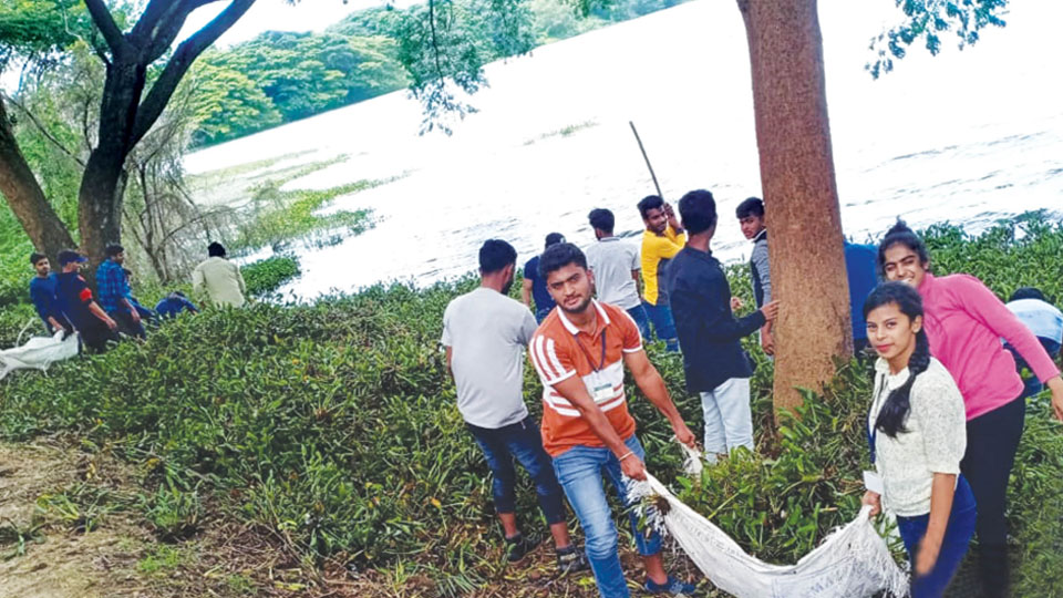 NSS students remove hyacinth weed at Kukkarahalli Lake
