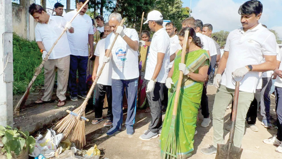 Minister, Mayor pick up broom, lift garbage