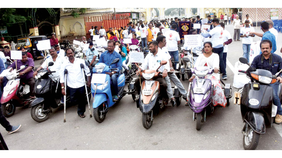 Disabled take out three-wheeler scooter rally seeking rights