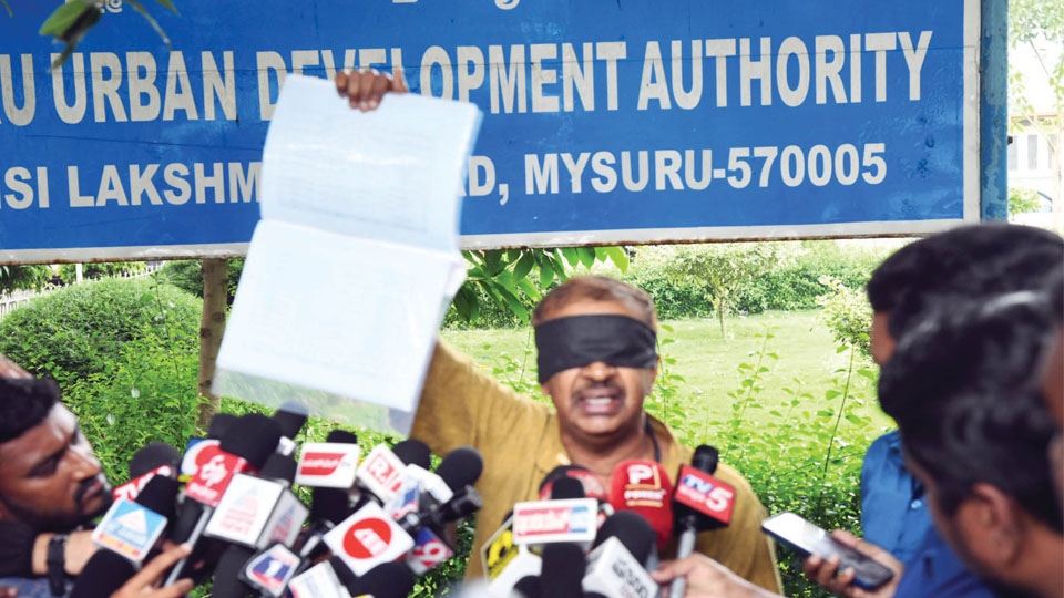 Blindfolded protest at MUDA meeting venue